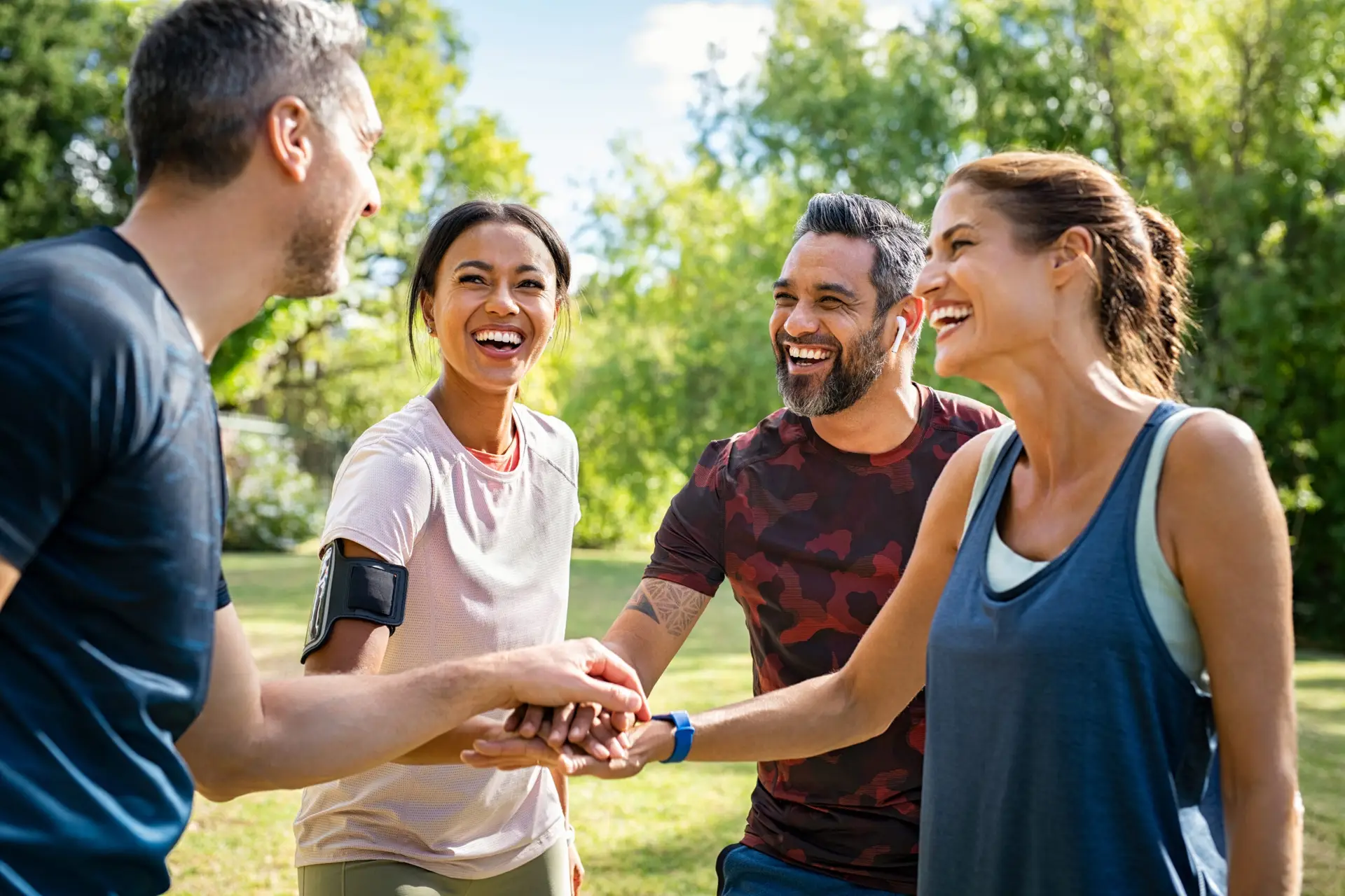 A group of smiling adults enjoying an outdoor wellness seminar hosted by The Maxim Clinic in Norcross–Marietta, discussing healthy lifestyle tips.