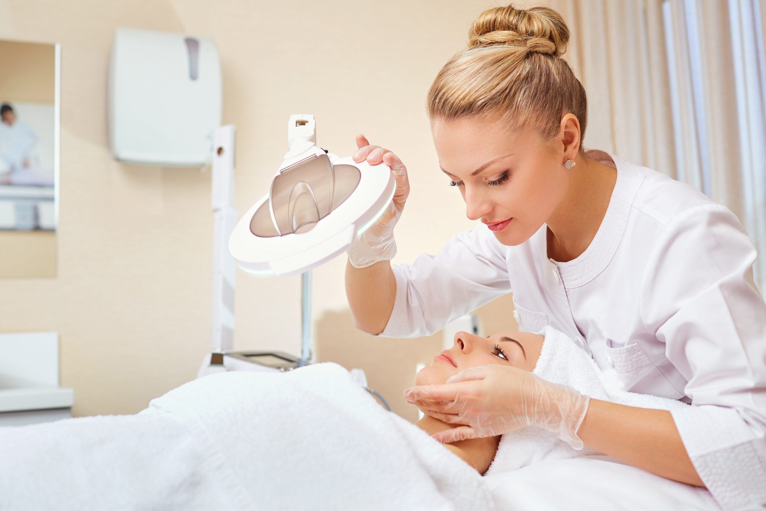 A professional esthetician performing a detailed skin analysis on a client